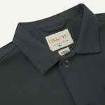 Dark gray jacket with a brand label on a light gray background