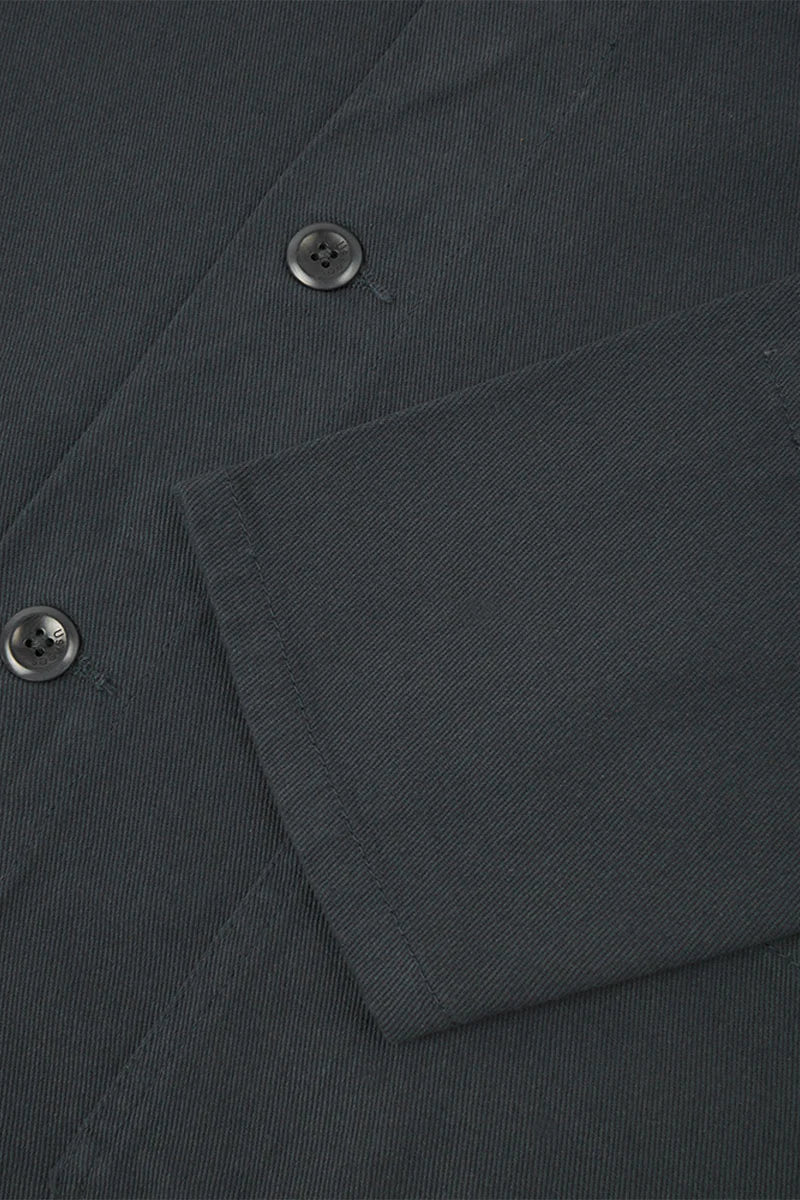 Close-up of a dark gray fabric with buttons and a pocket