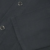Close-up of a dark gray fabric with buttons and a pocket