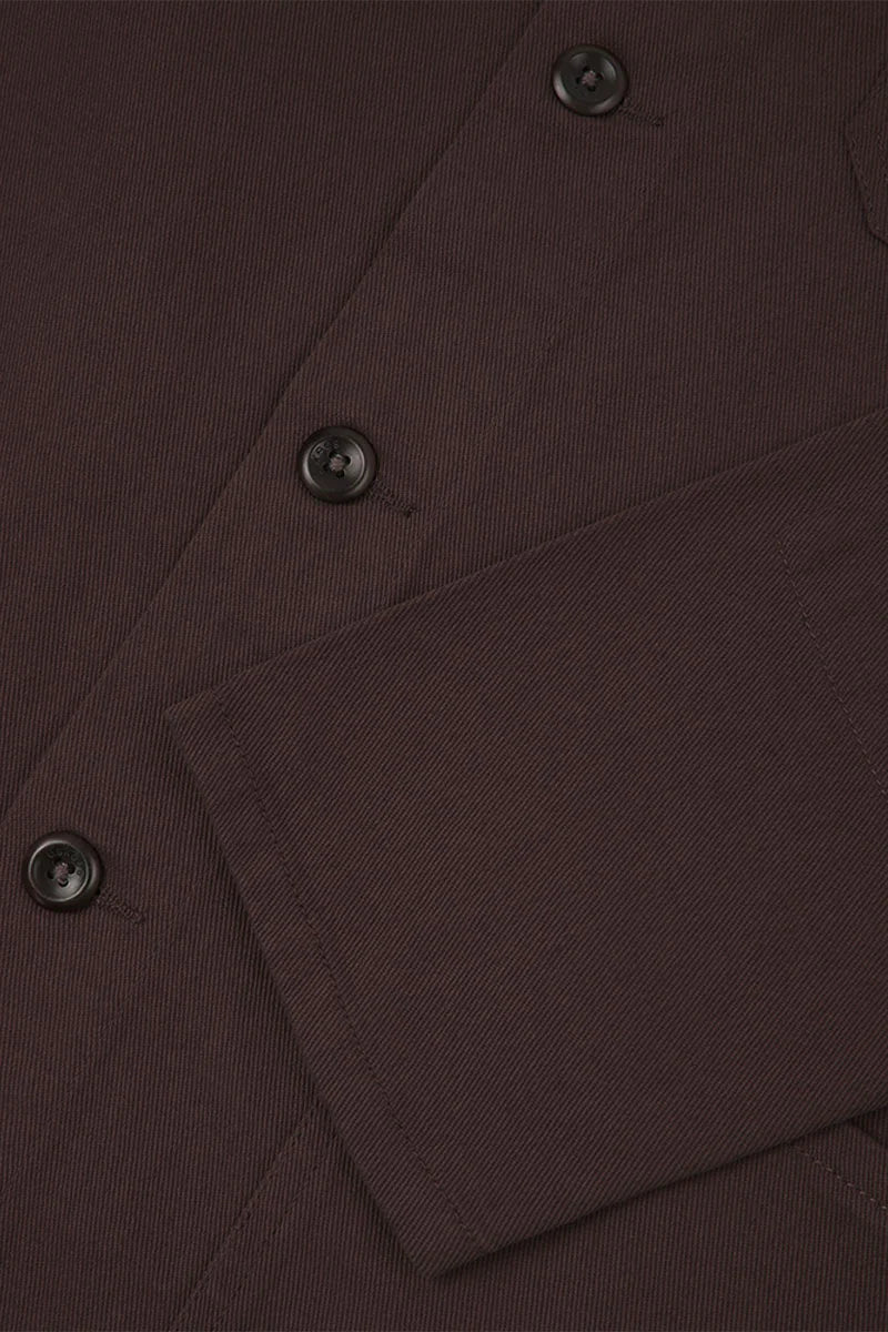 Close-up of a Dark Plum  fabric with buttons and a pocket
