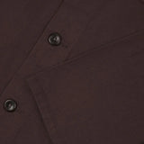 Close-up of a Dark Plum  fabric with buttons and a pocket