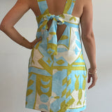 Woman wearing a patterned dress with a white background