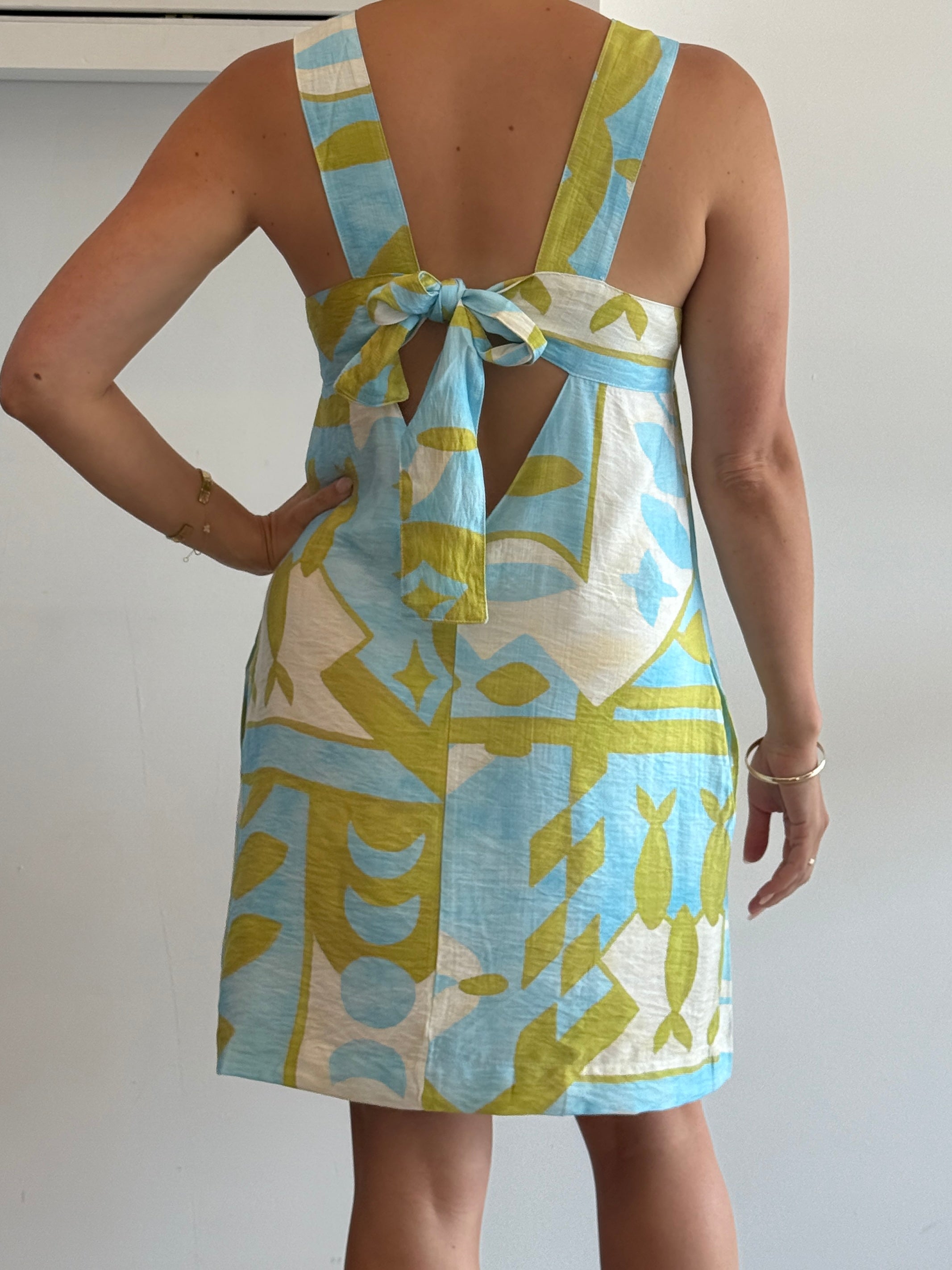 Woman wearing a patterned dress with a white background