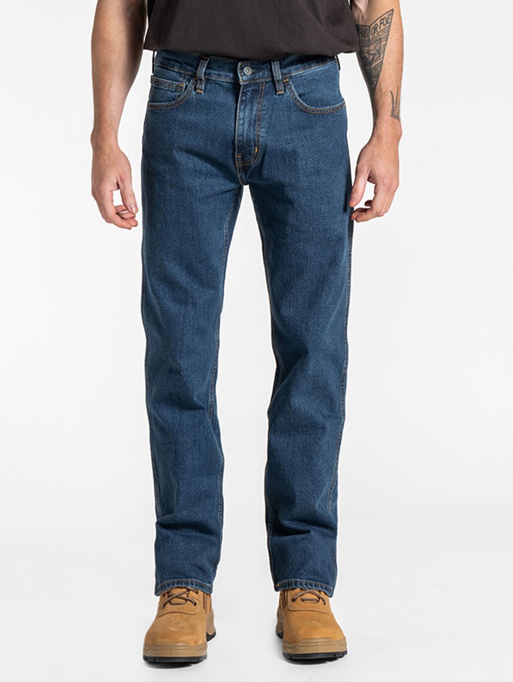 A person standing straight facing forward, wearing regular dark stone wash Levis jeans and brown shoes.