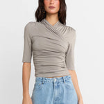 A woman shown wearing a Steel grey half-sleeve ribbed top and light-wash wide-leg denim jeans, against a plain white studio background.