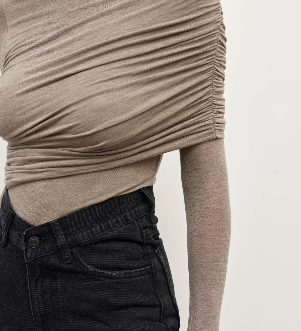 Beige long-sleeve top worn by a person on a plain background