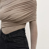 Beige long-sleeve top worn by a person on a plain background