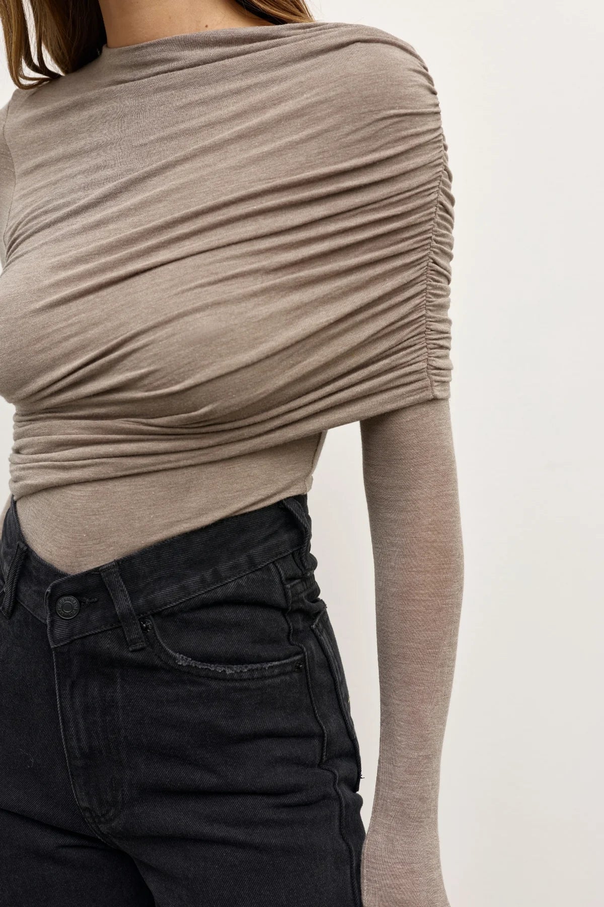 Beige long-sleeve top worn by a person on a plain background