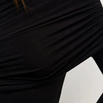 Close-up of a person wearing a black long-sleeve top with a white background