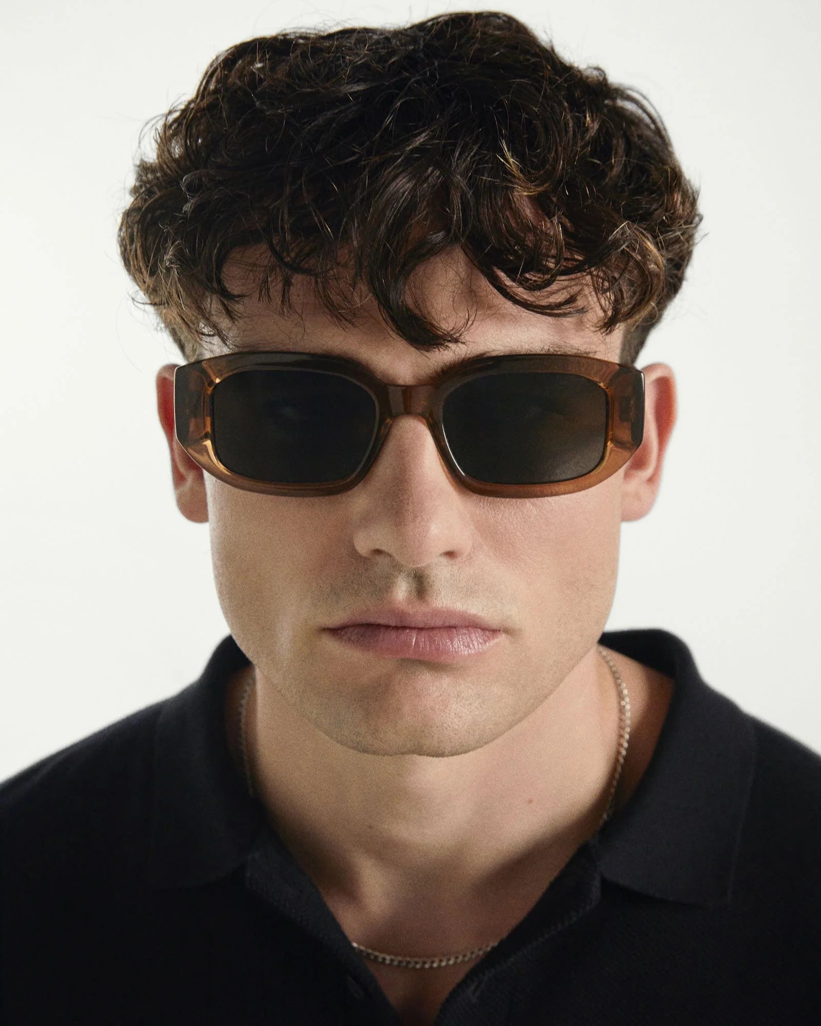 Man wearing sunglasses with a neutral background