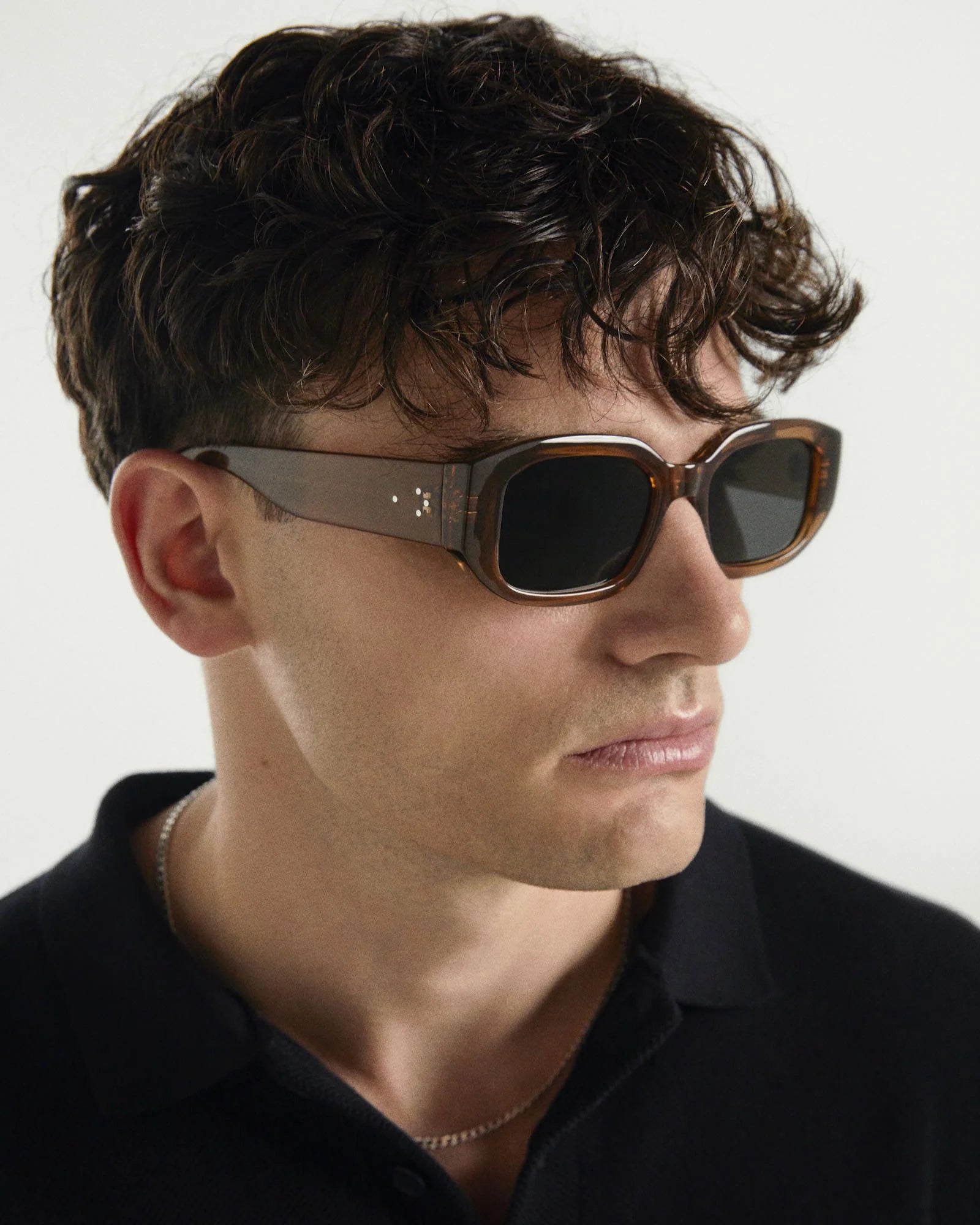 Man wearing sunglasses with a neutral background