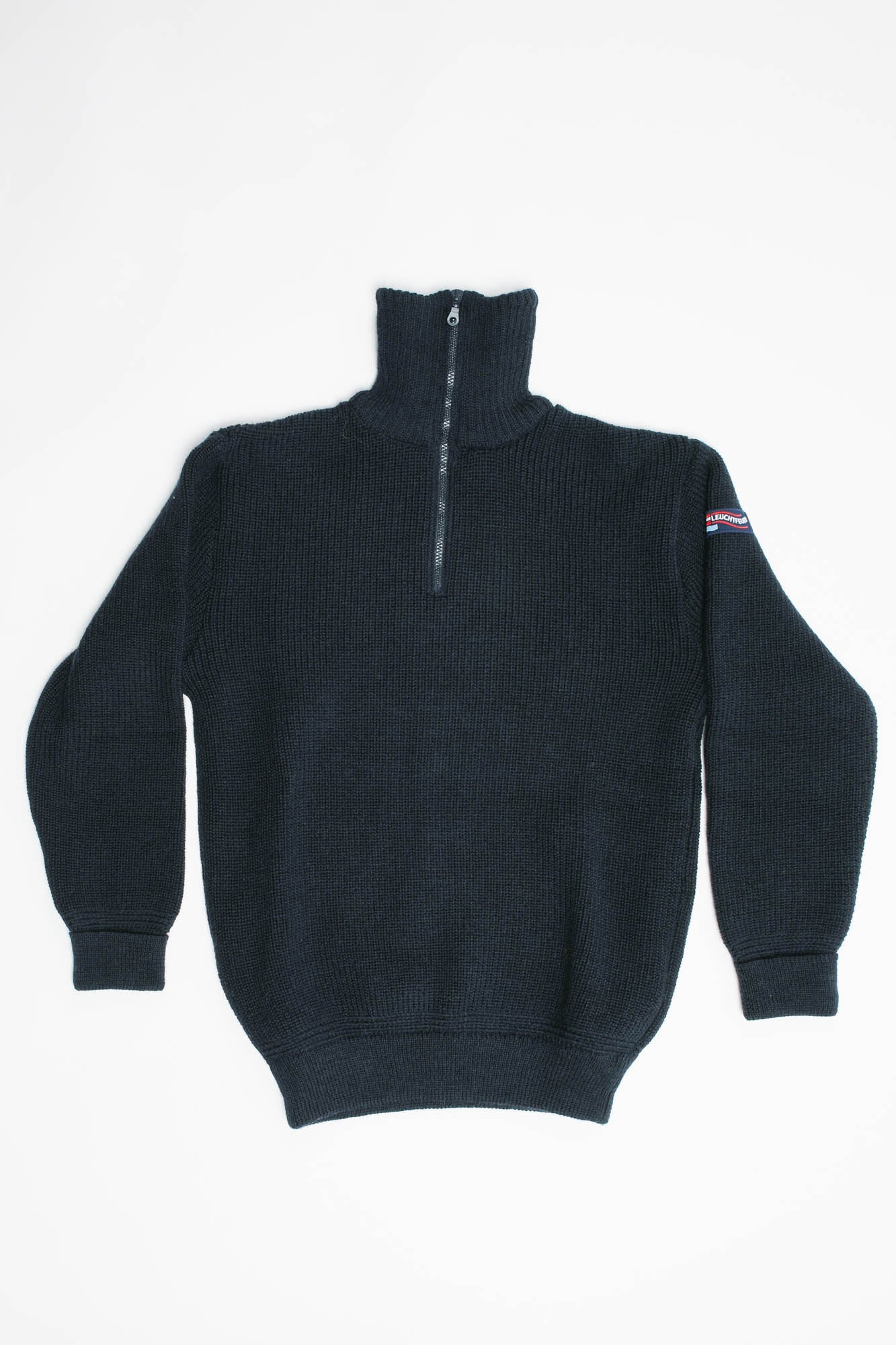Blue half-zip sweater with a small logo on the sleeve against a white background