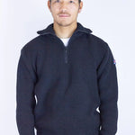 Man wearing a dark blue sweater with a small logo on a white background