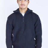 Man wearing a dark blue sweater with a small logo on a white background