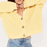Person wearing a yellow sweater and light blue jeans on a white background