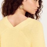 Woman wearing a yellow sweater against a white background