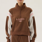 Person wearing a brown tracksuit with 'A.James' branding on a white background