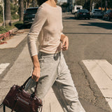 Woman walking on a street holding a handbag