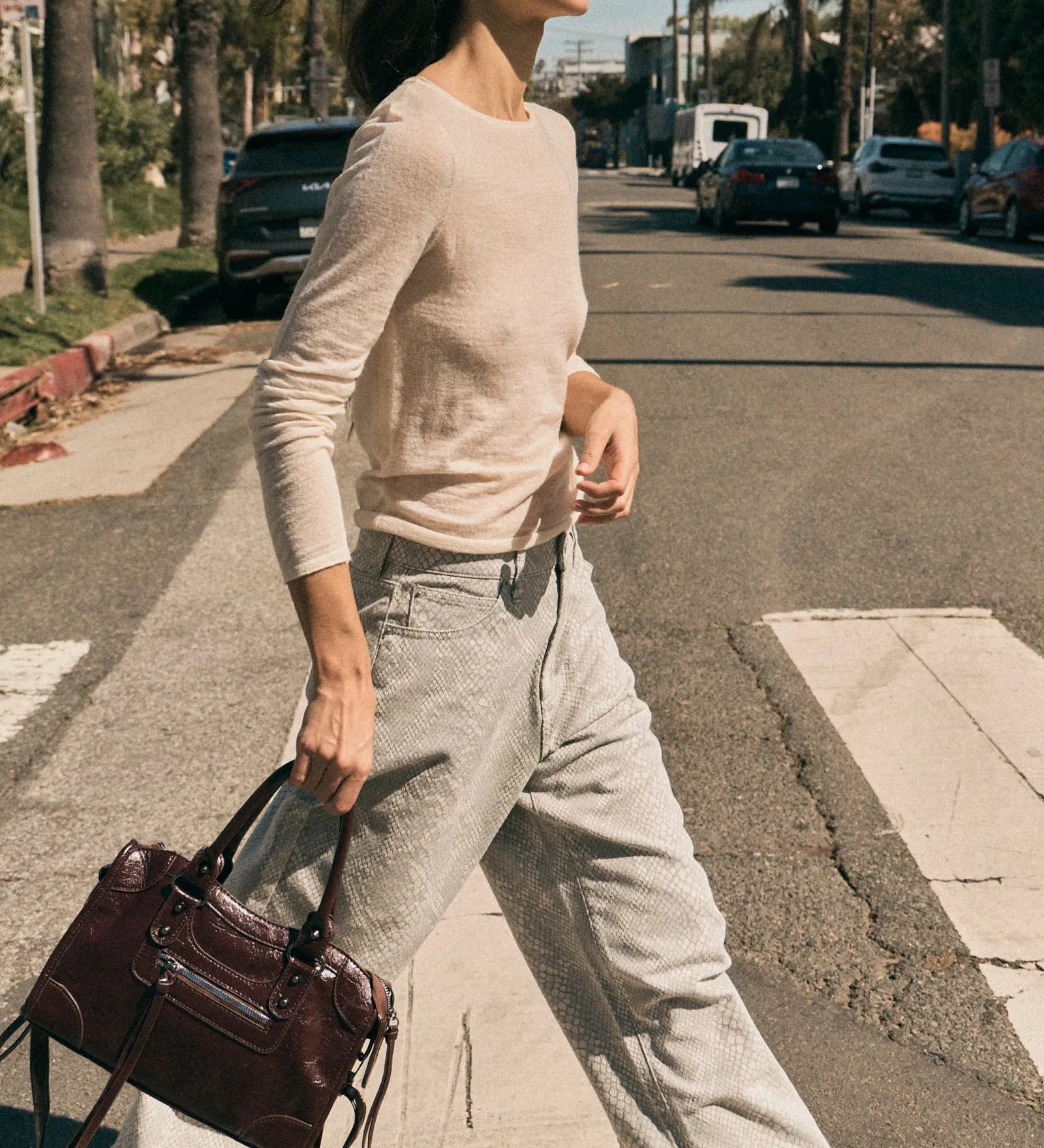 Woman walking on a street holding a handbag