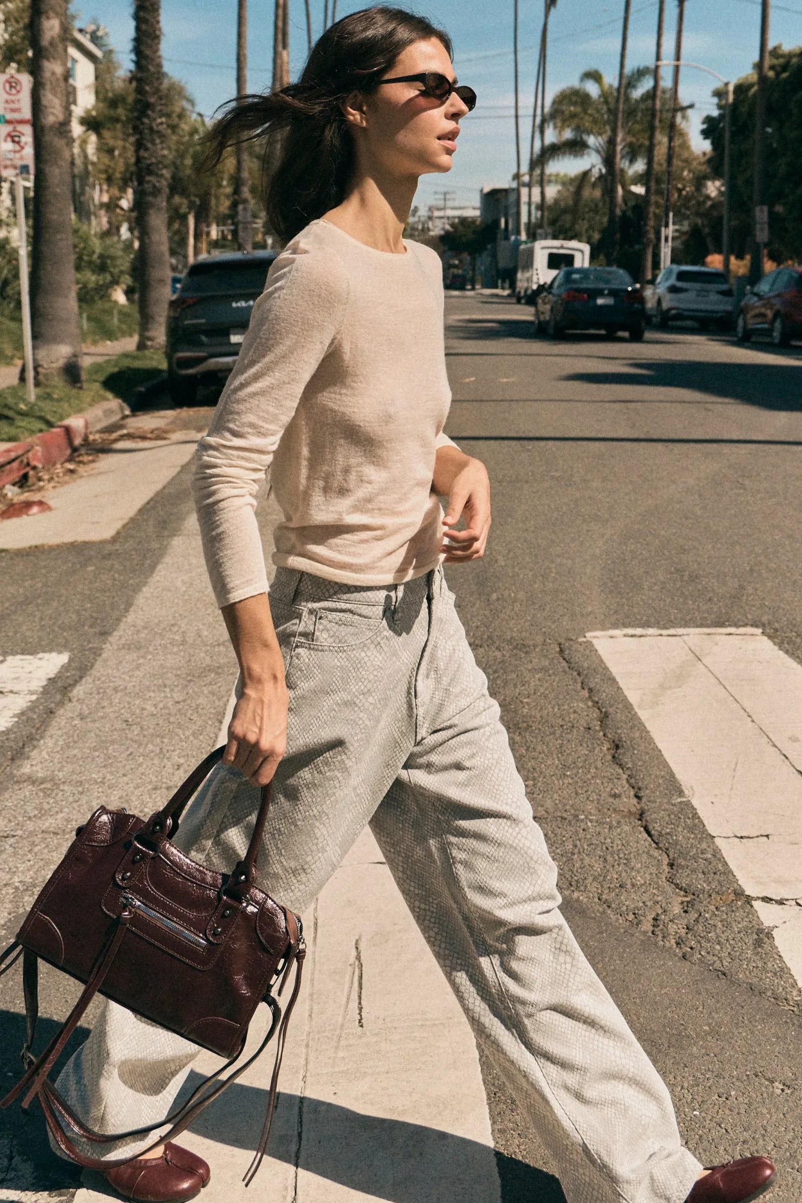 Woman walking on a street holding a handbag