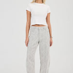 Woman wearing a white crop top and gray pants on a white background