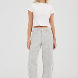 Woman wearing a white crop top and gray pants on a white background