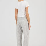 Woman wearing a white t-shirt and gray pants on a white background