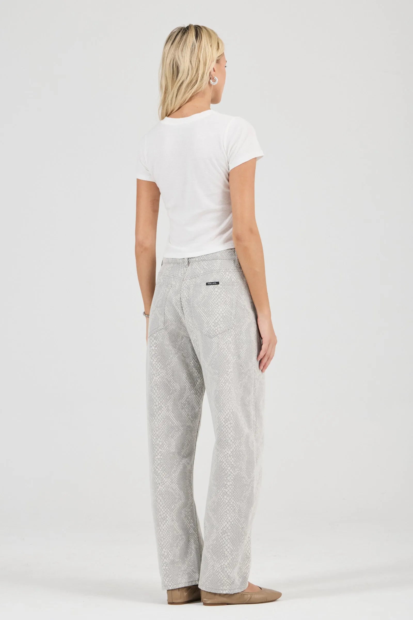 Woman wearing a white t-shirt and gray pants on a white background