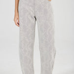 Person wearing light gray patterned pants on a white background