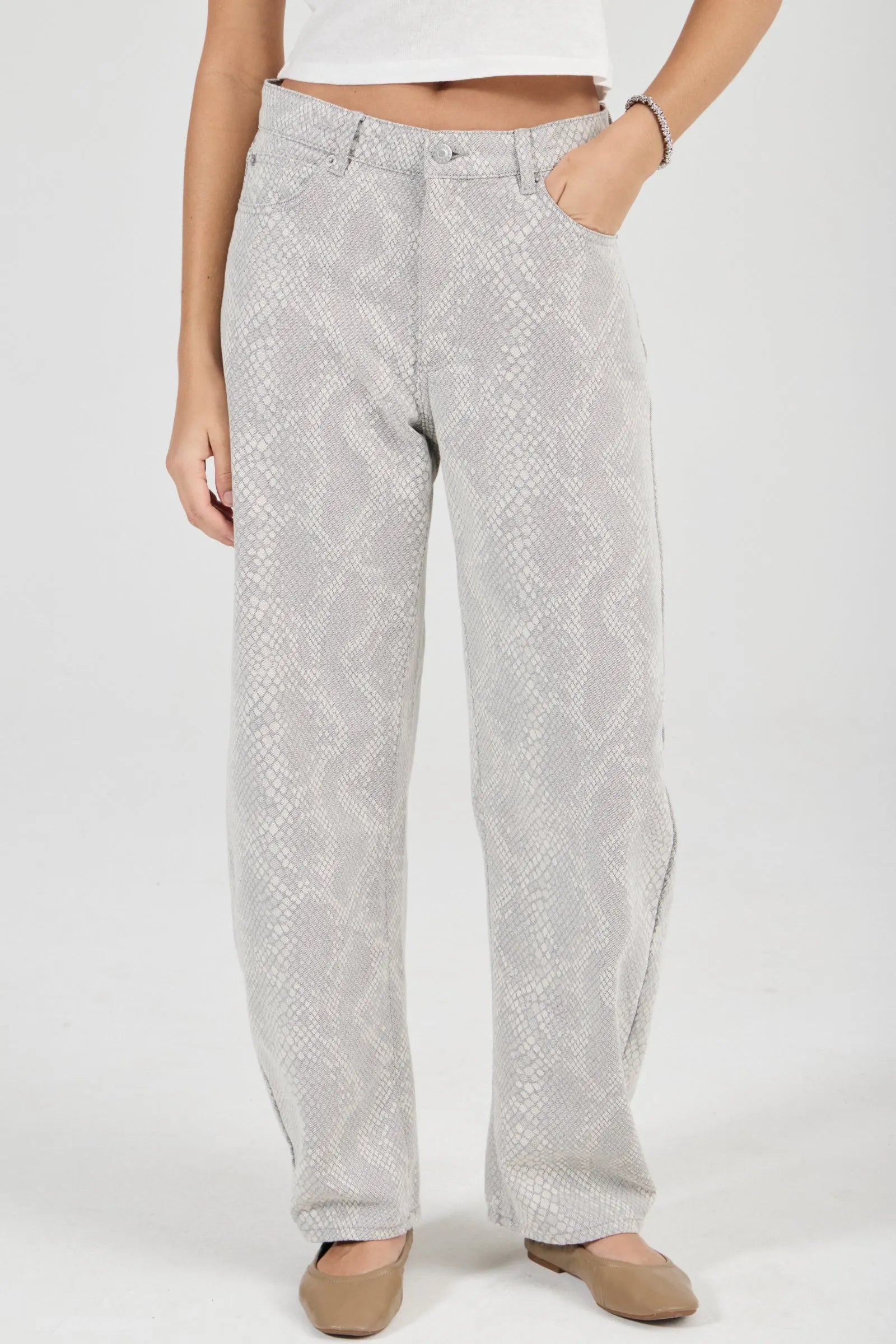 Person wearing light gray patterned pants on a white background