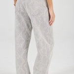 Person wearing light gray patterned pants on a white background