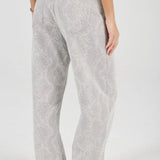 Person wearing light gray patterned pants on a white background