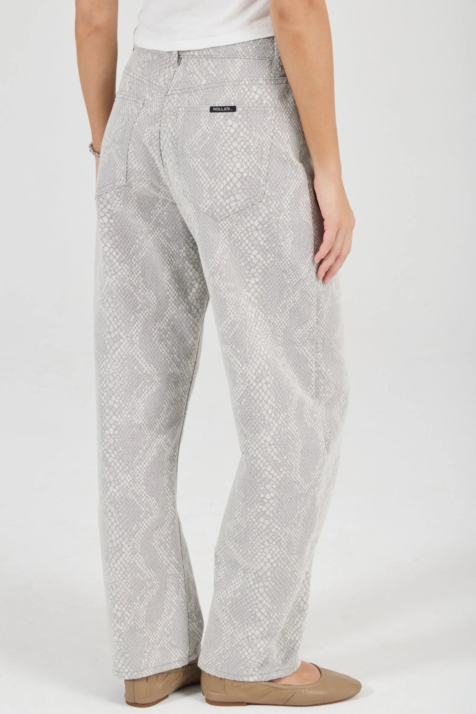 Person wearing light gray patterned pants on a white background