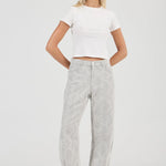 Woman wearing a white crop top and gray pants on a white background