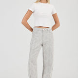 Woman wearing a white crop top and gray pants on a white background