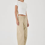 Woman wearing a white top and beige pants on a white background