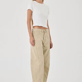 Woman wearing a white top and beige pants on a white background