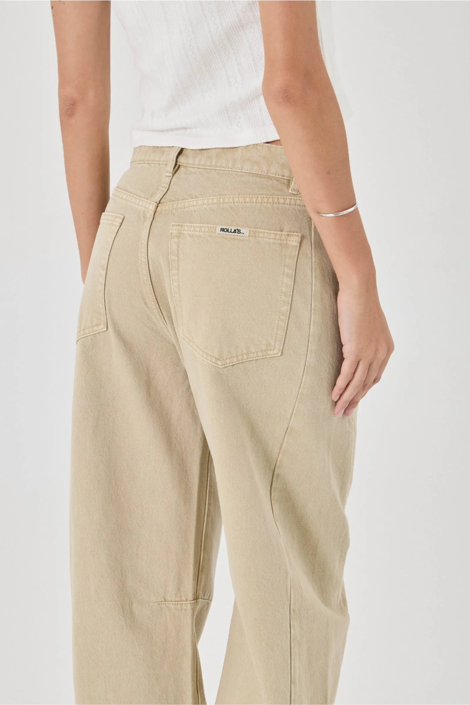 Beige pants worn by a person on a white background