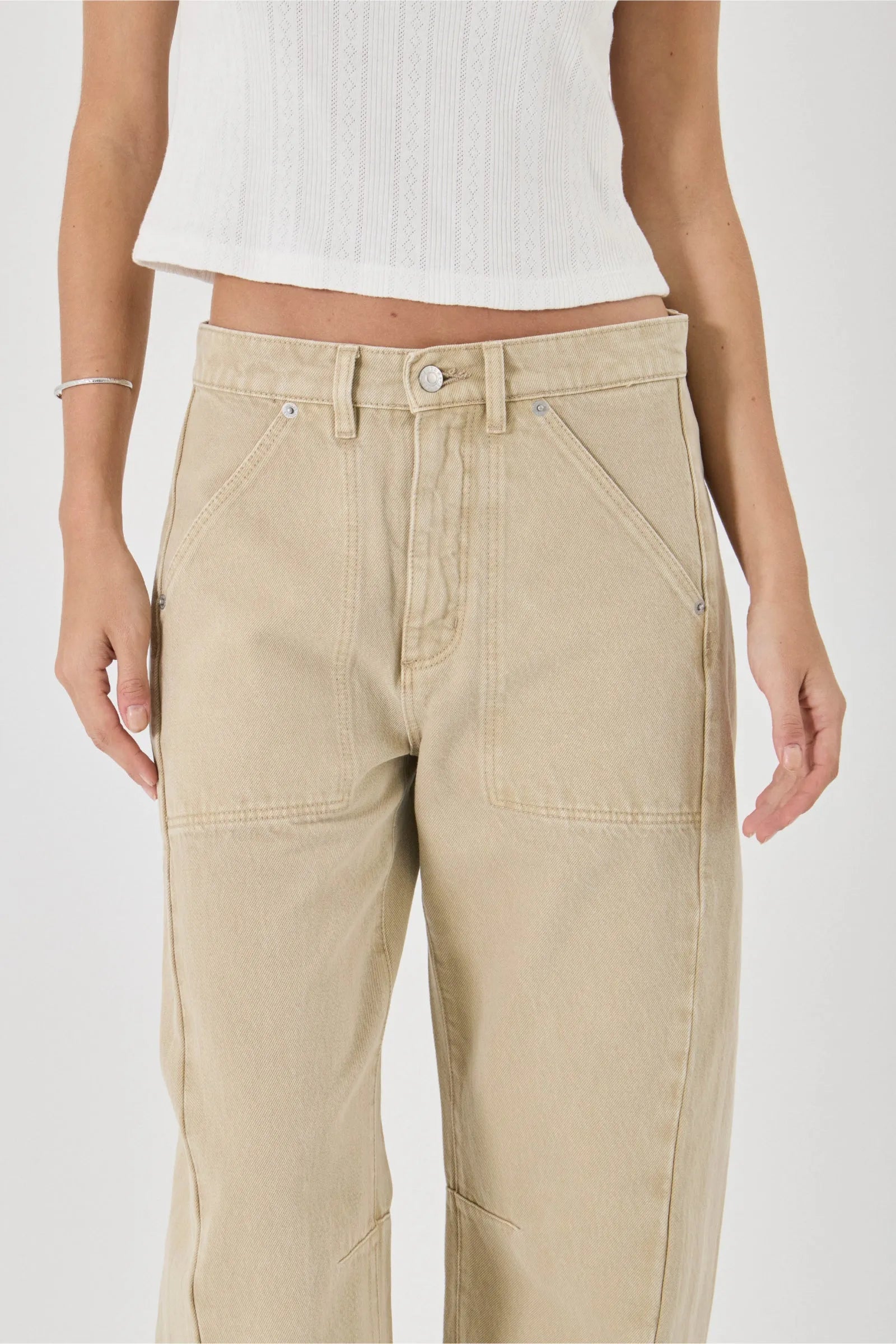 Beige pants worn by a person on a white background