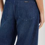 Blue jeans worn by a person on a white background