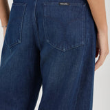 Blue jeans worn by a person on a white background