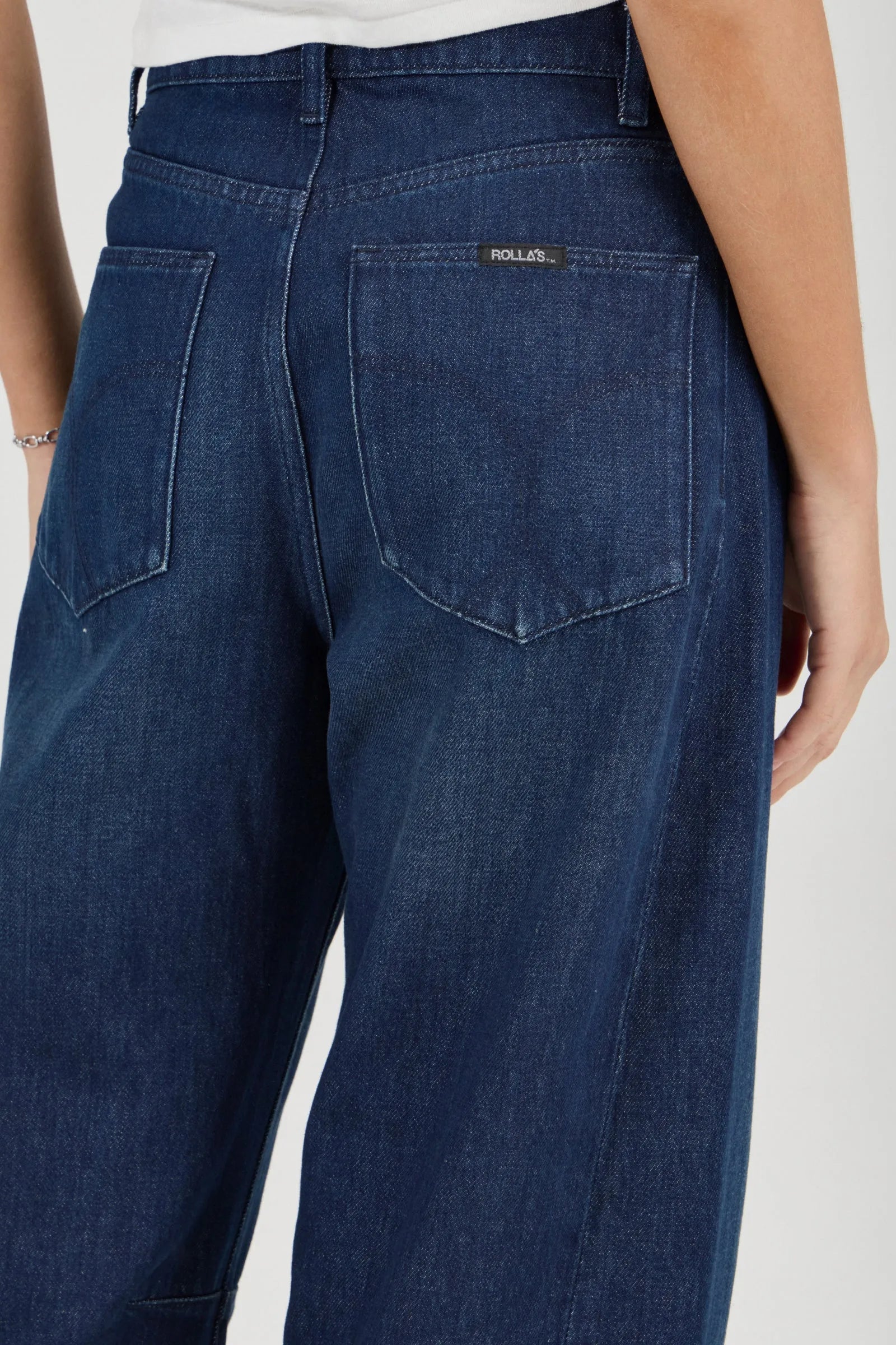 Blue jeans worn by a person on a white background