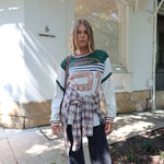 Person wearing a Printed Long sleeve Jersey and dark jeans with plaid shirt around waiste