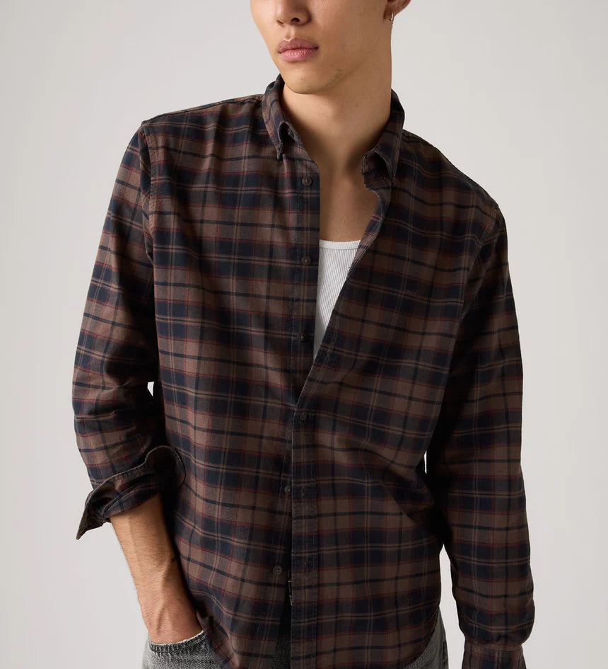 Person wearing a plaid shirt with a plain background