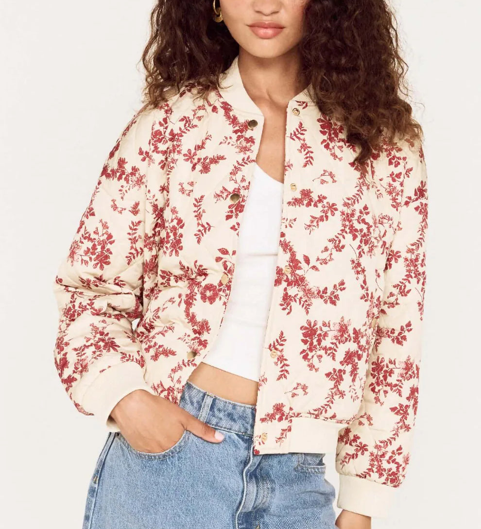 Woman wearing a floral bomber jacket and jeans on a white background
