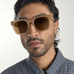 Man wearing brown sunglasses with a neutral background