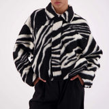 Person wearing a zebra-striped coat against a white background