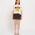 Woman wearing a cream t-shirt with 'MAKU' print and a brown skirt on a white background