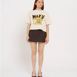 Woman wearing a cream t-shirt with 'MAKU' print and a brown skirt on a white background