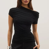 Woman wearing a black off-shoulder top and black pants against a plain background